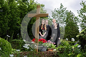 Family mourning at grave on cemetery