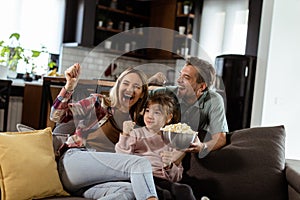 Family Movie Night: Engrossed in Thrilling Scenes at Home