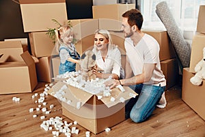 Family Moving. Happy People With Boxes In New Apartment