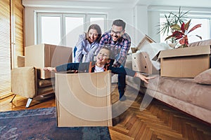 Family moving home with boxes around, and having fun