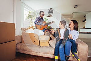 Family moving home with boxes around, and having fun