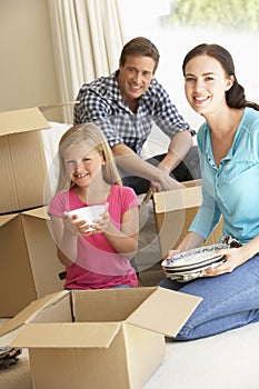 Family Moving Into New Home Surrounded By Packing Boxes