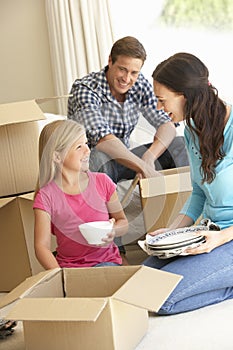 Family Moving Into New Home Surrounded By Packing Boxes