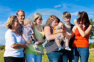 Family and multi-generation - fun on meadow in summer