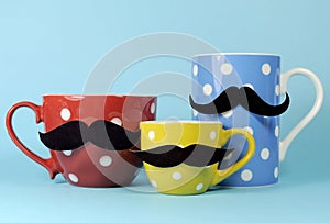A family of mustaches on blue, red and yellow polka dot coffee and tea cups and mugs
