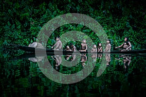 Family of native indigenous Orinoco tribe Warao swimming in traditional wooden canoe among the mangroves