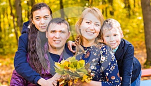 Family, nature, autumn and people concept - Portrait of Happy mother, father, son and daughter in fall