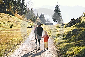 Family in nature outdoor. Woman with kids on hiking trail in mountains