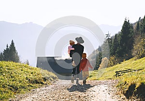 Family in nature outdoor. Woman with kids on hiking trail in mountains