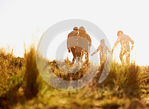 Family, nature and walk at sunset, bonding and exercise for parents and children. Lens flare, autumn and grass for hike