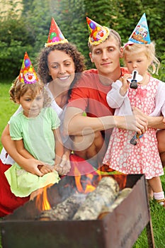 Family near brazier on picnic, happy birthday photo