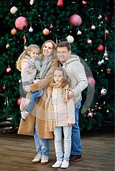 Family near Christmas tree in shopping center