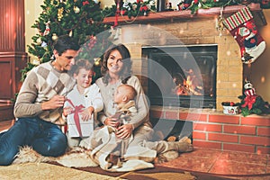 Family near fireplace in decorated house interior