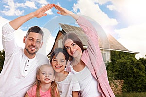 Family near their house with solar panels. Alternative energy source