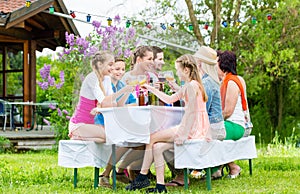 Family and neighbors at garden party drinking