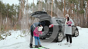 A family with one child spend fun time in nature. Family holiday in the winter forest.