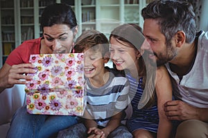Family opening the surprise gift in living room