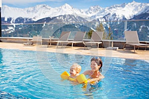 Family in outdoor swimming pool of alpine spa resort