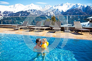 Family in outdoor swimming pool of alpine spa resort