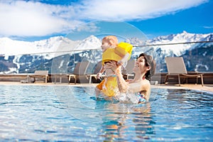 Family in outdoor swimming pool of alpine spa resort