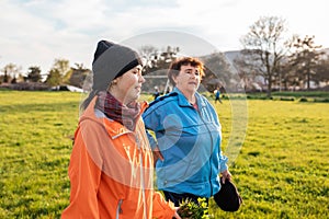 Family outdoor vacation. Older smiling grandmother walking down the park with her granddaughter. International Day of