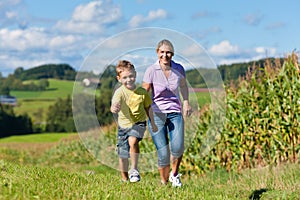 Family outdoors is running on a meadow