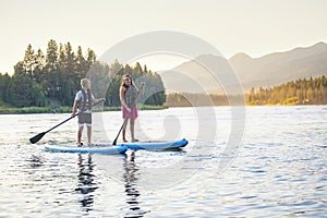 Family Paddleboarding together on a Beautiful Mountain Lake