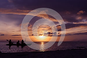 Family paddling a kayak by the sea.