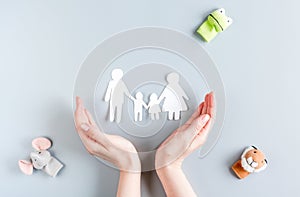 Family paper figures in adopting concept on gray background top view mockup