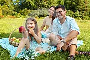 Family In Park. Happy Young Parents And Child Relaxing Outdoors