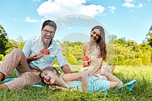 Family In Park. Happy Young Parents And Child Relaxing Outdoors