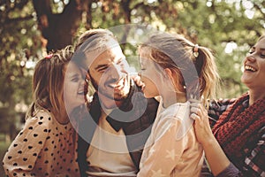 Family in park having conversation and hugging.