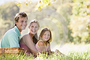 Family at park having a picnic and smiling