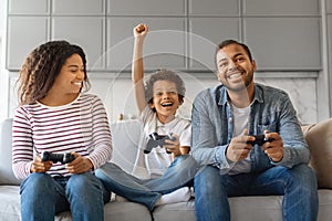 Family Pastime. Cheerful Black Parents Playing Video Games With Son At Home