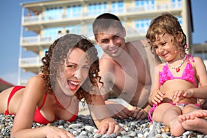 Family on pebble in swimwear photo