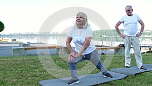 A family of pensioners is engaged in fitness in a city park. Morning Exercise