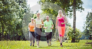 Family with personal Fitness Trainer jogging