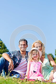 Family photo with father, mother and daughter in meadow