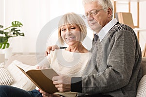 Family photoalbum. Senior couple looking at photos