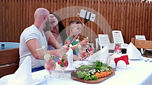 Family photos make the mobile phone is placed on a stick selfi, cheerful gatherings parents with children, dinner al