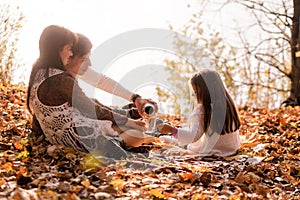 Family picnic in the autumn park. Family drinking tea