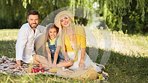 Family picnic. Parents and daughter resting in nature