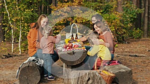 Family on a picnic at a resting place in a pine forest