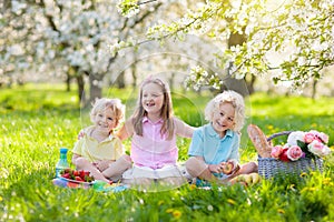 Family picnic in spring park. Kids eating outdoors