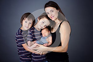 Family picture of three boys and their mom, kissing and hugging