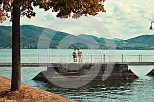 A family on the pier of the Trasimeno Lake in a summer day Umbria, Italy