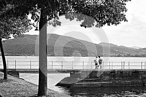A family on the pier of the Trasimeno Lake in a summer day Umbria, Italy