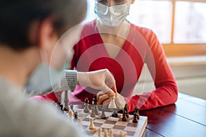 Family playing board games during curfew moving chess pieces