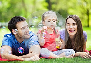 Family playing with bubbles outdoors