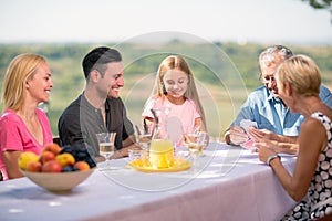 Family playing cards outdoors